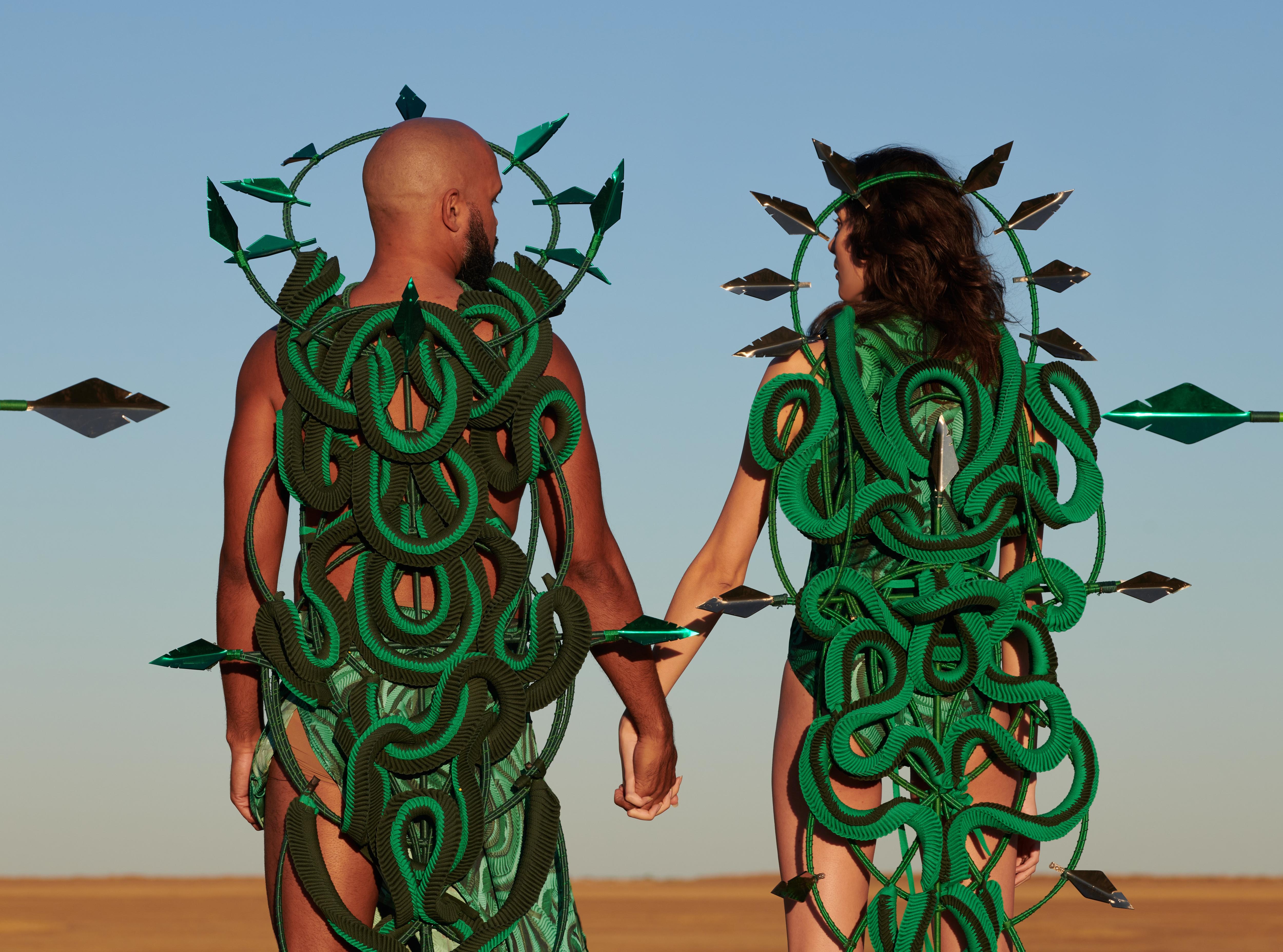 duas pessoas vestidas com fantasias de cobra verde