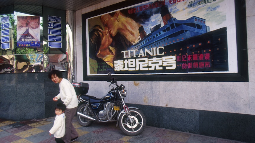 A mother and child walk past a poster for 'Titanic' in Shanghai in 1998 