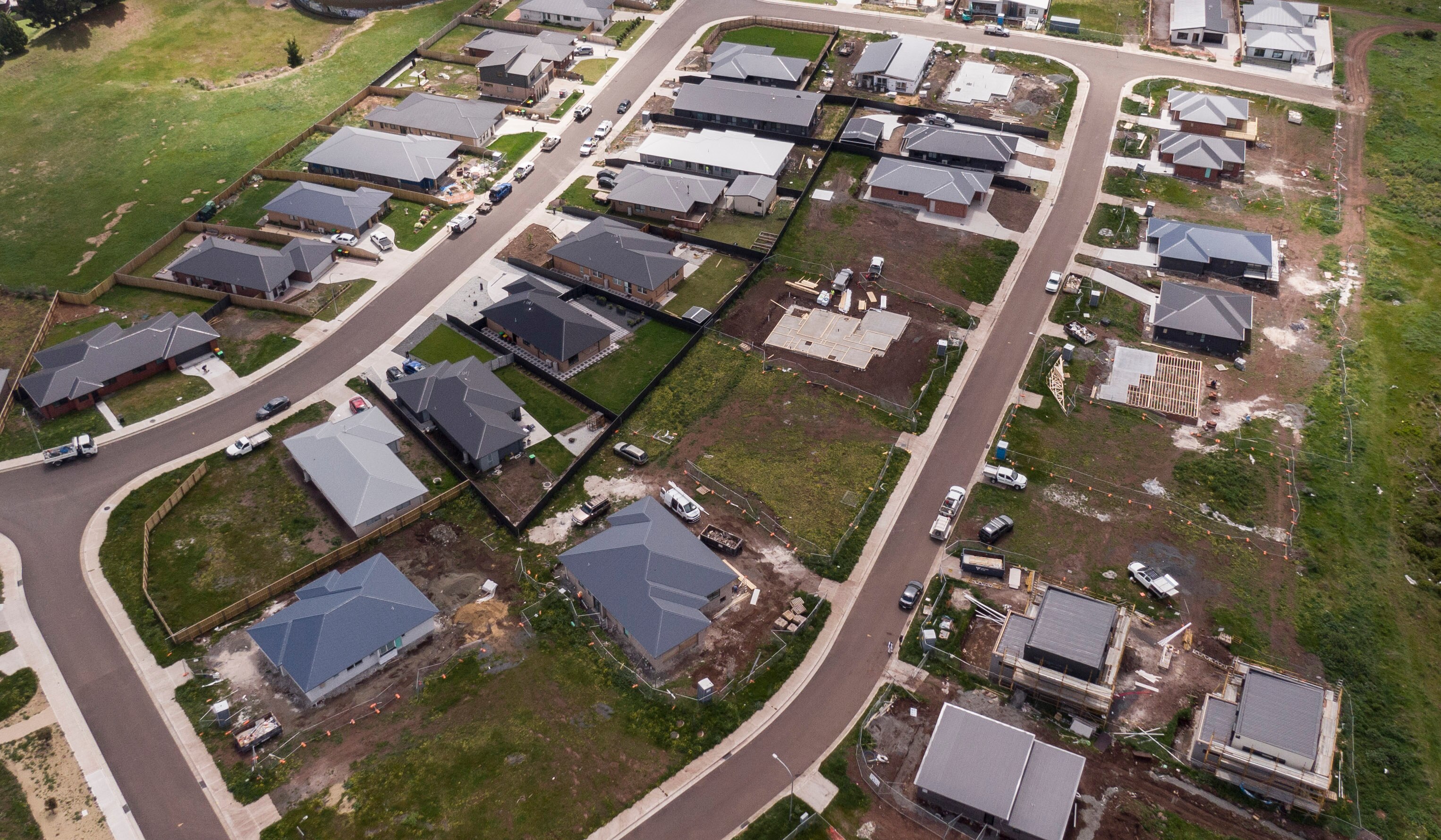 Homes on a block in various stages of construction in a new suburban area. 