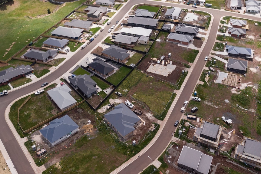 Homes on a block in various stages of construction in a new suburban area. 