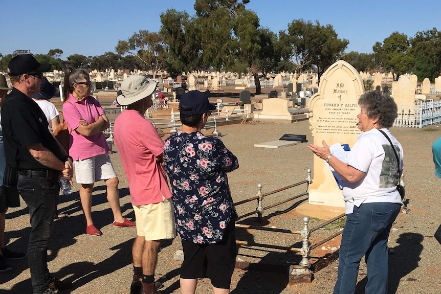 A group of people looking at a grave