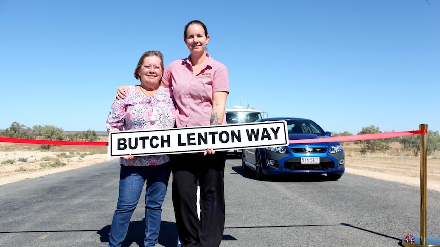 Ros Lenton and Carly Cox hold sign for Butch Lenton Way named after the late mayor of Winton