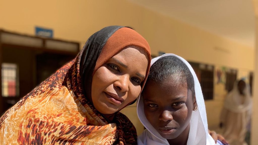 A woman and a girl wearing headscarves smile at the camera after participating in an anti-FGM workshop.