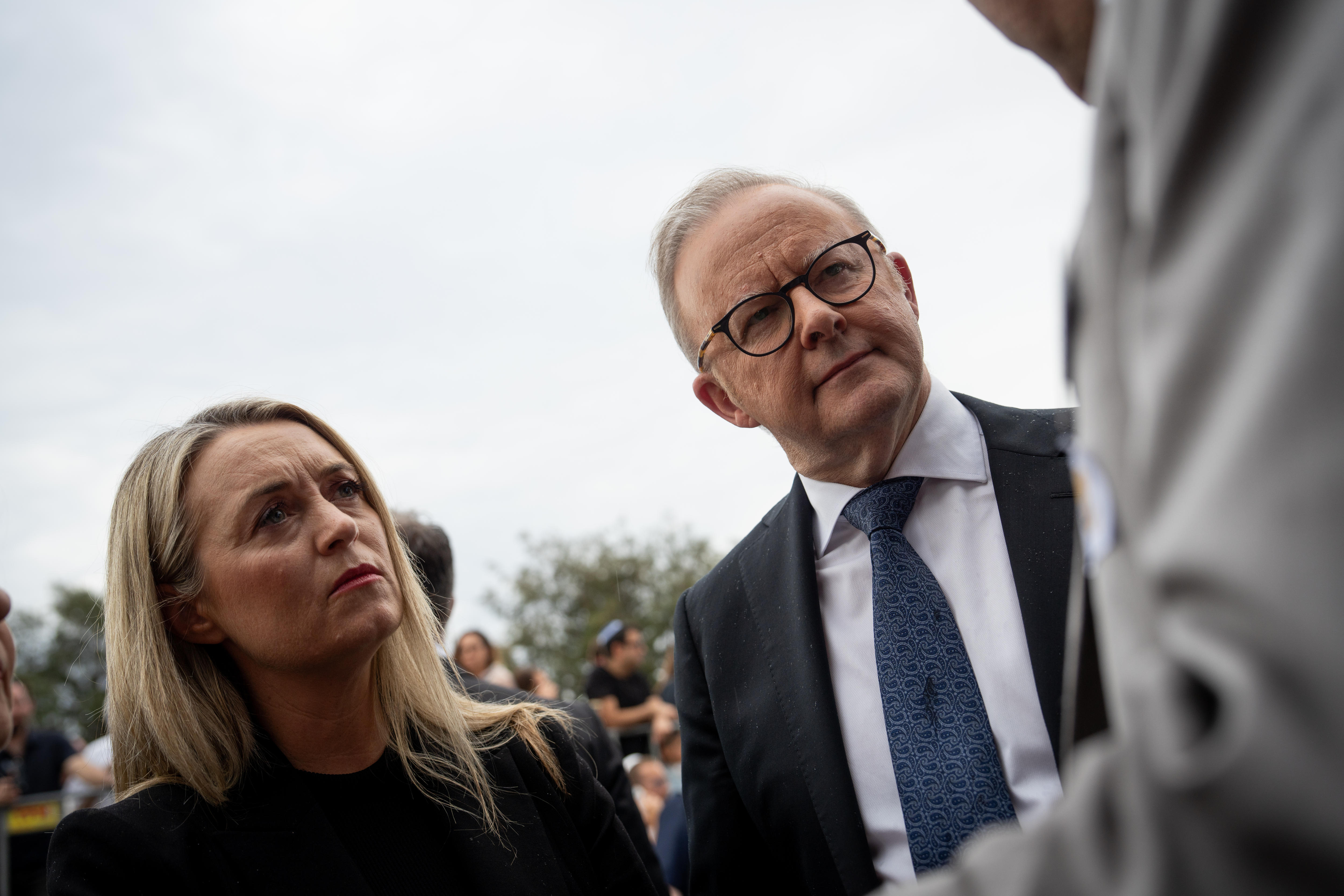 Anthony Albanese e Jodie Hayden, lado a lado, ouvindo alguém falar.
