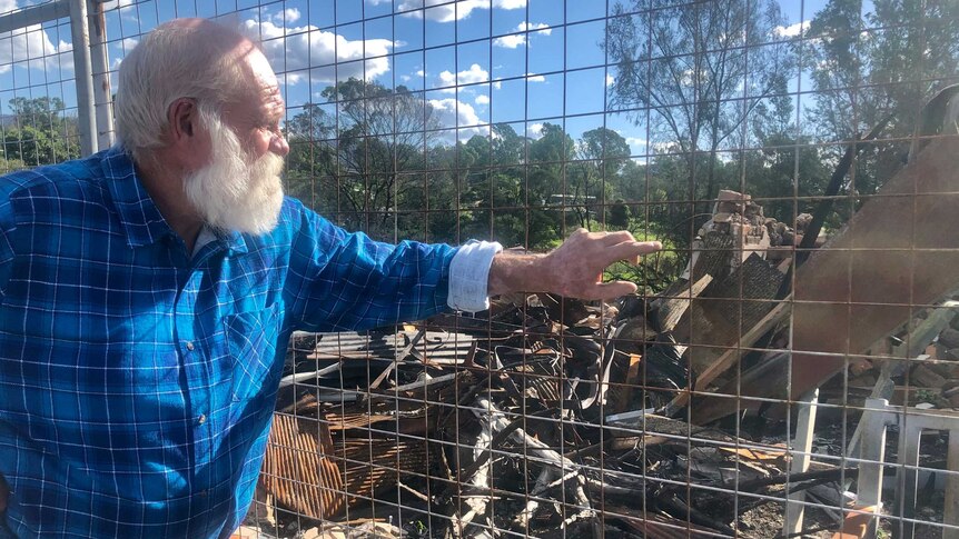 David Rugendyke looks onto bushfire rubble in Cobargo