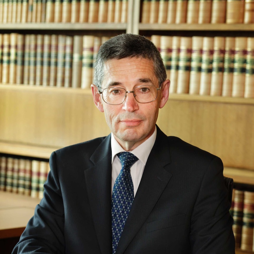 Official portrait of Justice Geoffrey Nettle in front of a bookcase