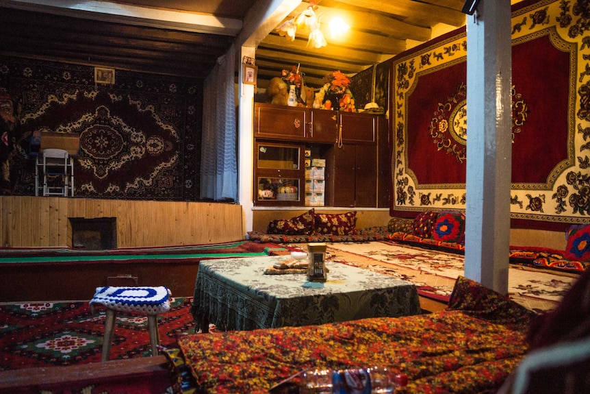 A richly decorated room with rugs on the walls