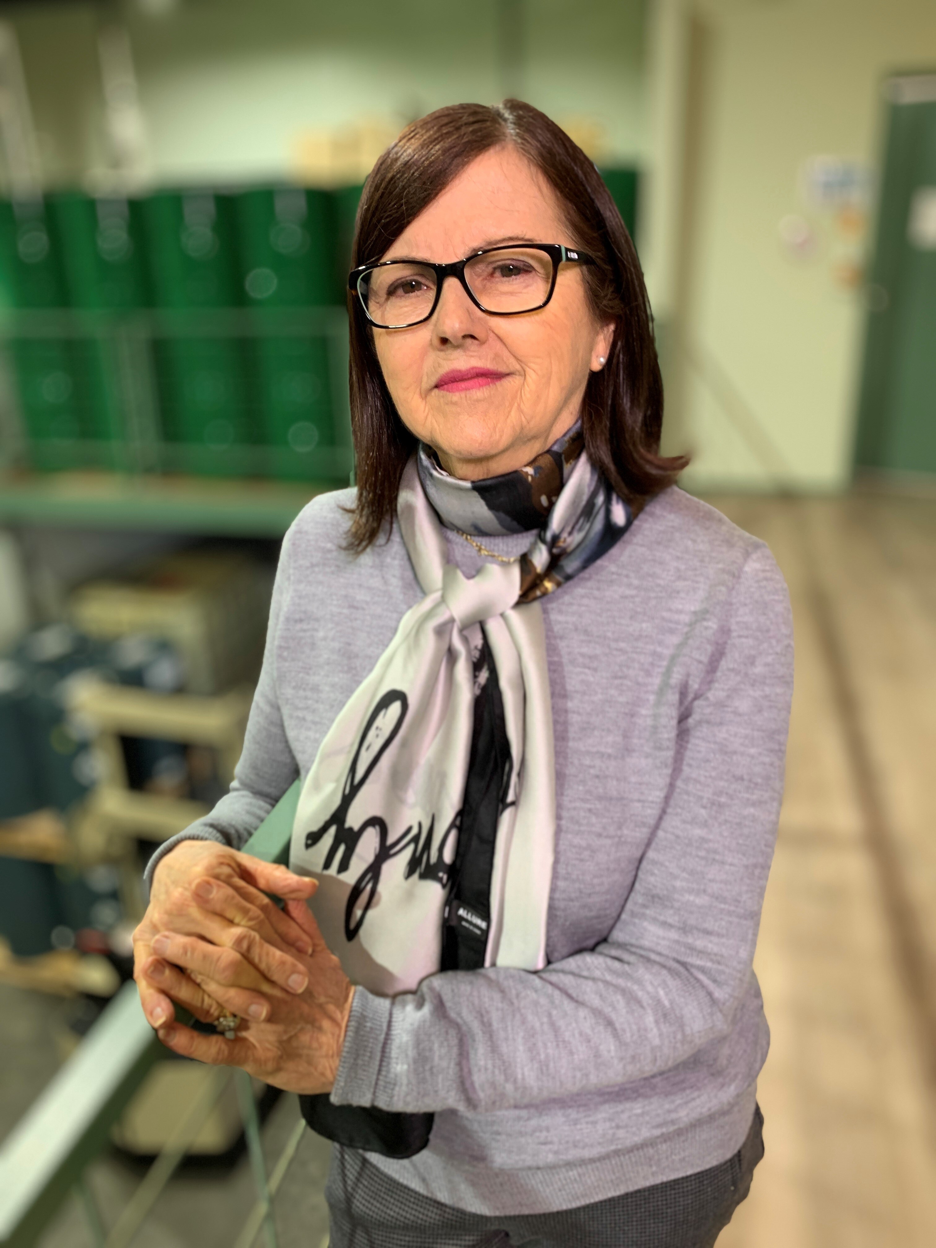 A woman wearing glasses and a scarf.