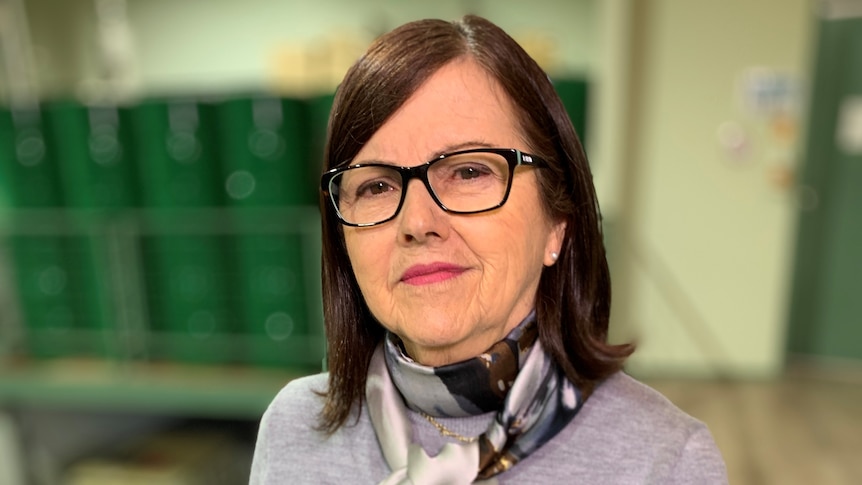 A woman wearing glasses and a scarf.