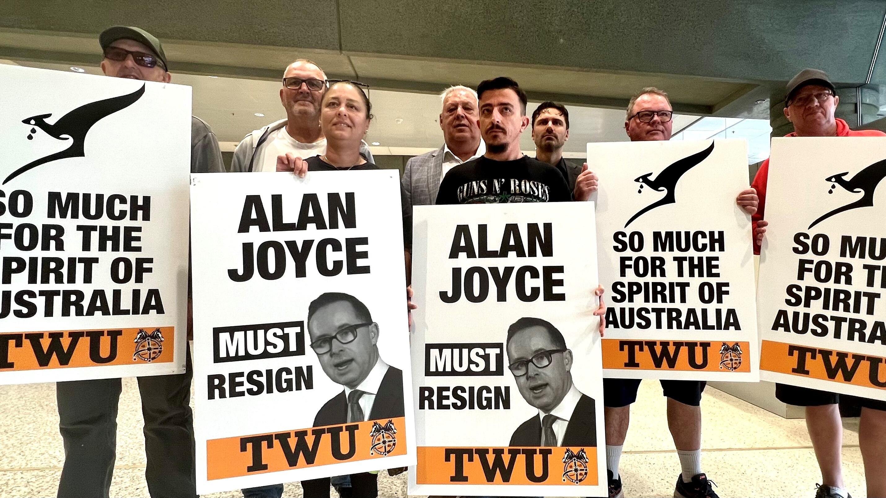 People protest against Qantas boss Alan Joyce at Sydney airport