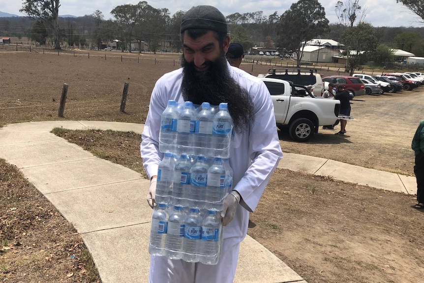 A man carries water for a barbecue