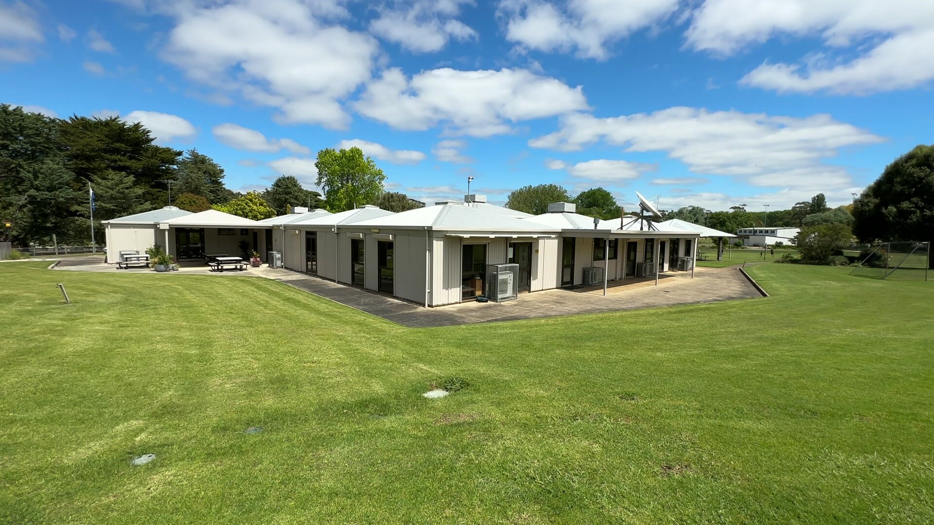 Exterior, aerial view of a school building surrounded by green grass.