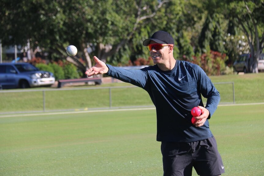 David Warner throws a ball in Darwin at a cricket session for women.