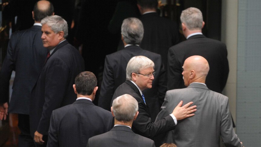 Labor MP Kevin Rudd walks past the Minister for Veterans' Affairs at Parliament House on June 26, 2013.