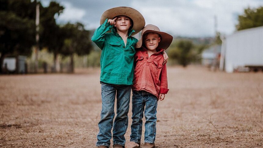 Two small boys in farm work wear.