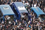 The bodies of Aryeh Kopinsky (C), Calman Levine (L) and Avraham Shmuel Goldberg lie in vehicles during their funeral.