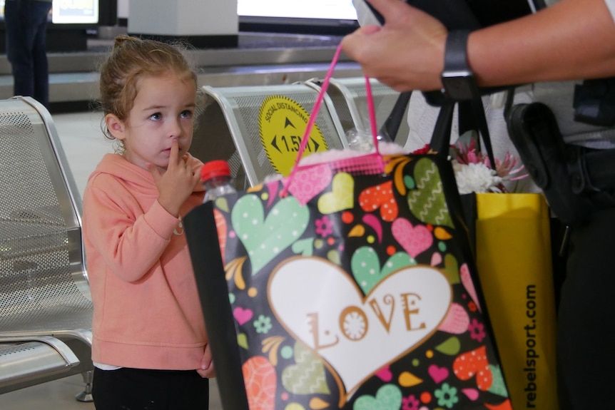 Three-year-old Nevaeh Austin with family at Rockhampton airport arrivals area.
