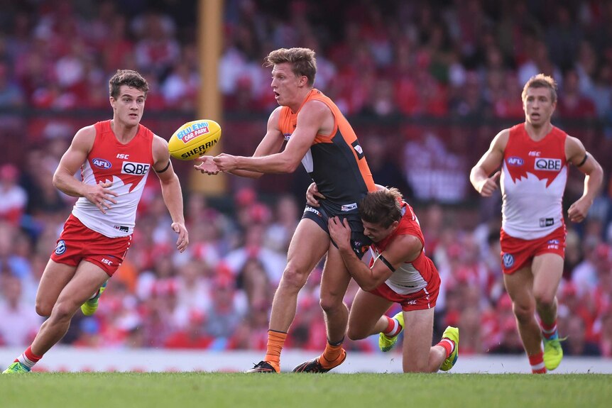 Jake Lloyd of the Swans tackles Lachie Whitfield of GWS at the SCG in April 2016.