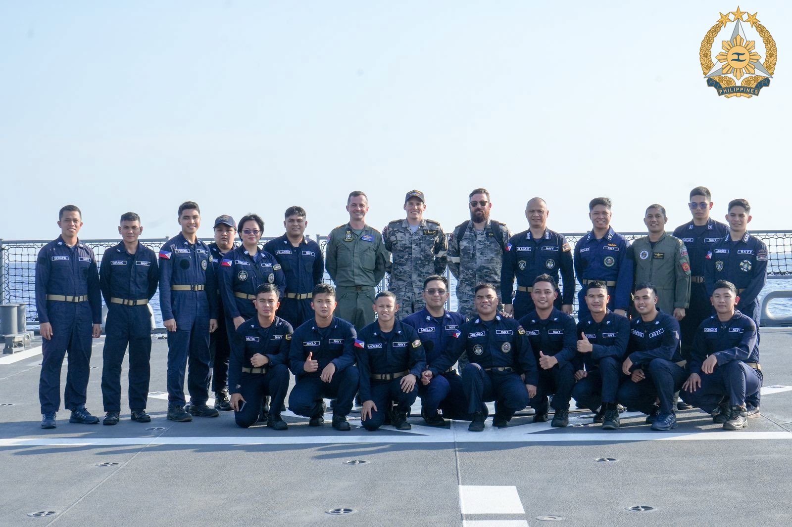A group photo of Navy personnel on the deck of a ship. 