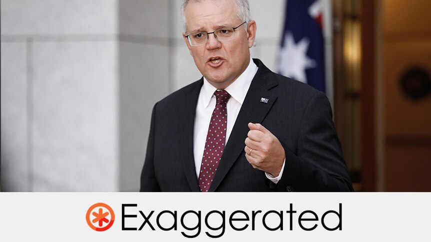 Prime Minister Scott Morrison wears a suit and gesticulates in front of Australian flag.