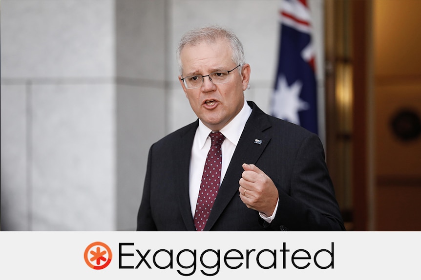 Prime Minister Scott Morrison wears a suit and gesticulates in front of Australian flag.