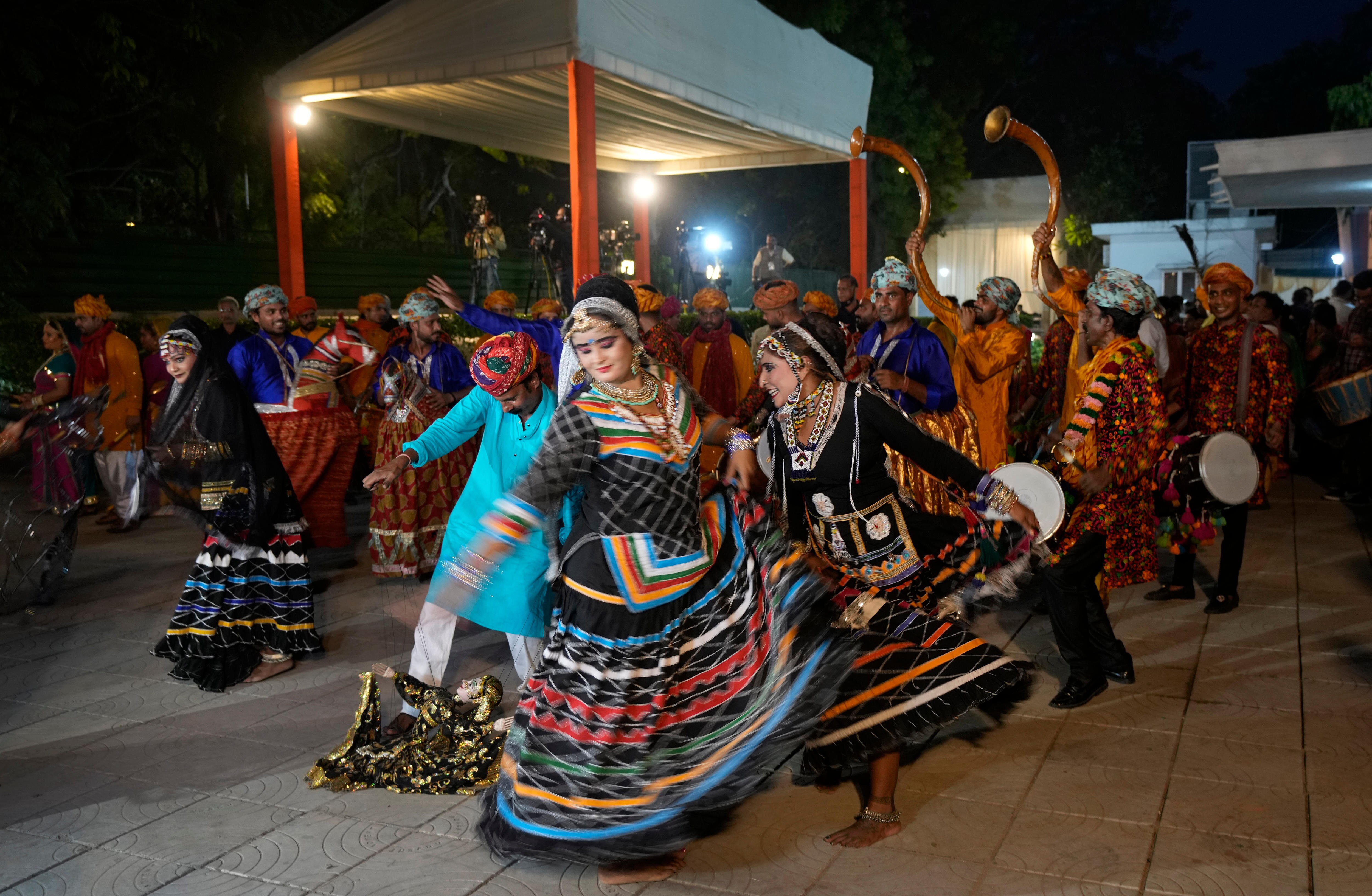 Folk artists dance in the street as they celebrate after Droupadi Murmu won the presidential election.