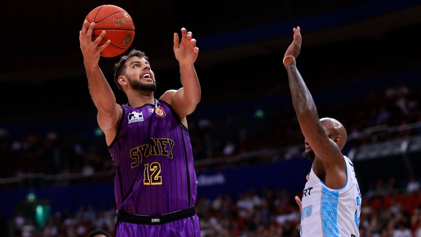 A Sydney Kings NBL player goes for a lay-up against the NZ Breakers.