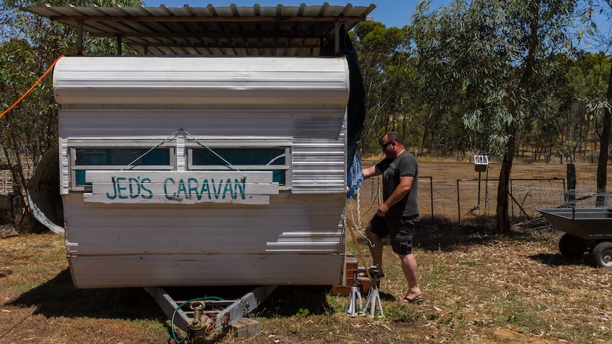 Brian Wilcox steps into one of the many caravans on his property to house homeless veterans.