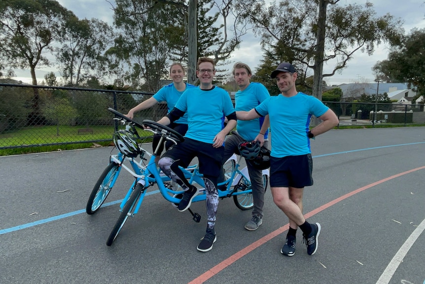 Guinness World Record breaking quadricycle team pose for photo on the track with quadricycle