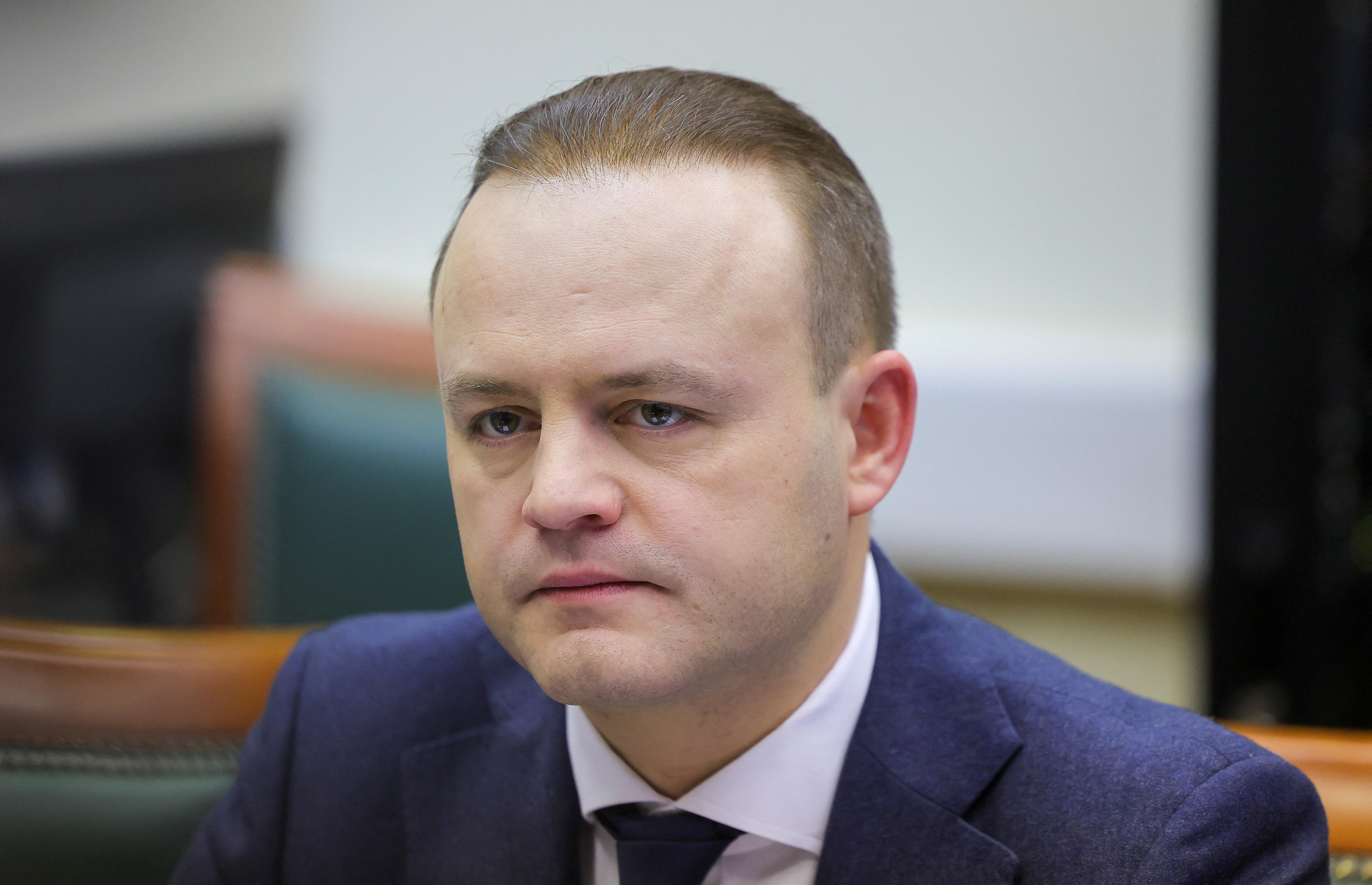 A man in a suit makes a serious expression 
