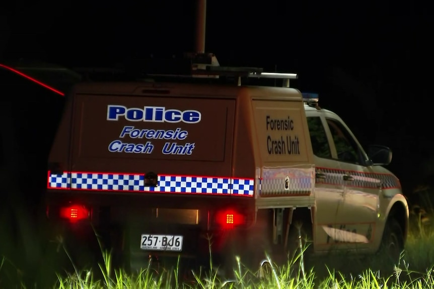 A forensic crash unit car at the scene at night.