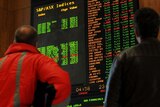 Investors watch the boards at the Australian Stock Exchange