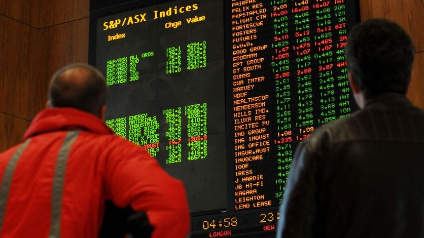 Investors watch the boards at the Australian Stock Exchange