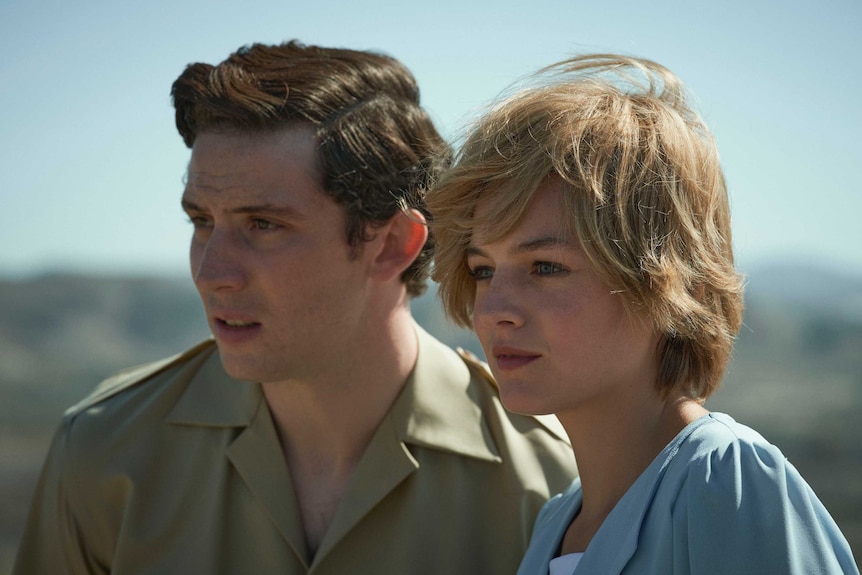 A young couple stand in an outback setting.