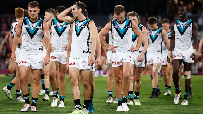 Dejected Port Adelaide players leaving the field of play.