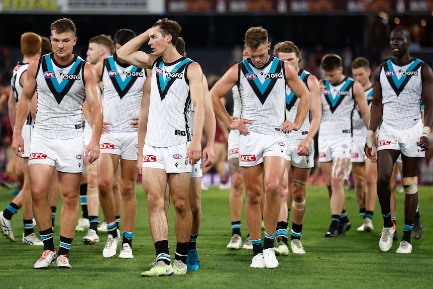 Dejected Port Adelaide players leaving the field of play.