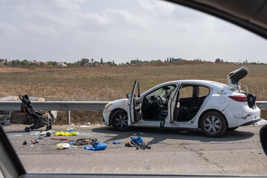 A baby pram and car on the road after Hamas attack