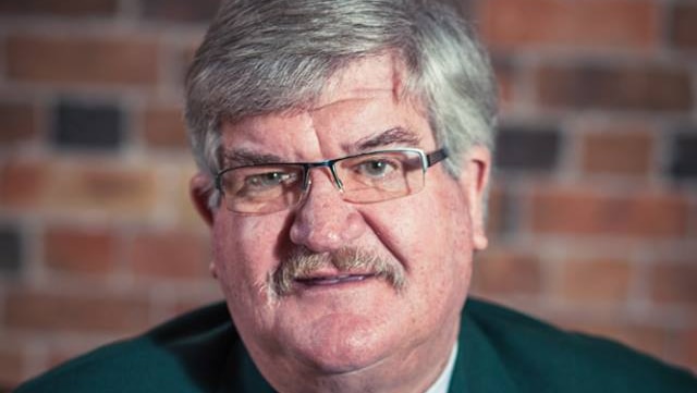 Former cricketer and Tasmanian MP Tony Benneworth in green jacket looks at the camera.