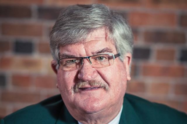 Former cricketer and Tasmanian MP Tony Benneworth in green jacket looks at the camera.