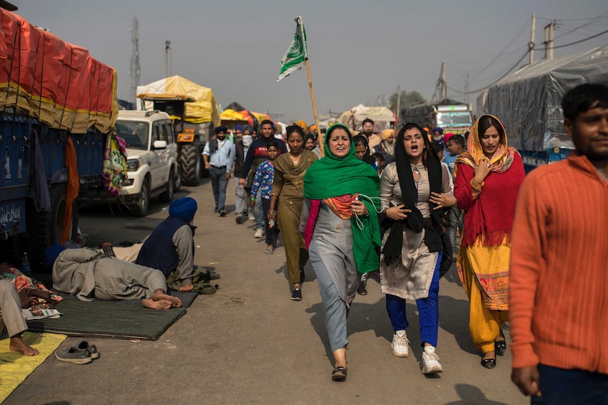 A group of women shout slogans as they arrive to join protesting farmers at the border between Delhi and Haryana state