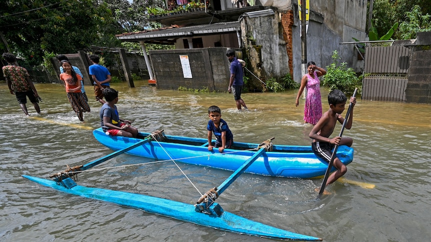children in a canoe in a flooded street