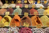 Three rows of various colourful spices piled high in tubs.