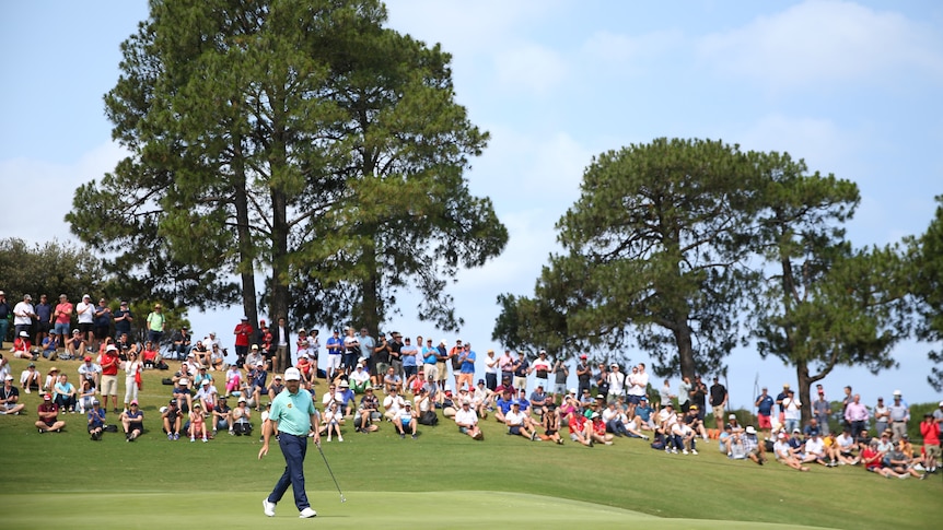 Louis Oosthuizen surveys the green as crowds sit on the hill at The Australian Golf Club