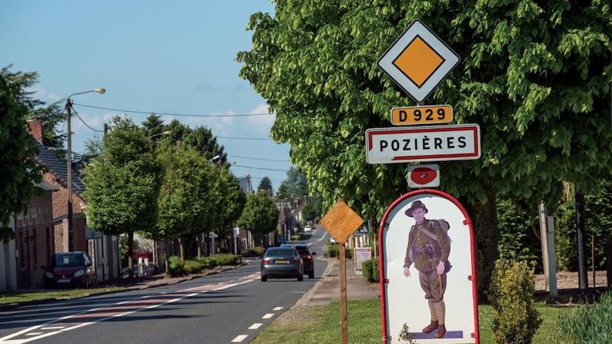A road side sign for Pozieres with the picture of an Australian soldier on it.