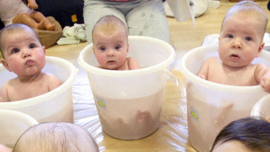 Babies sit in tubs filled with water to cool down after a baby massage class in the Netherlands.