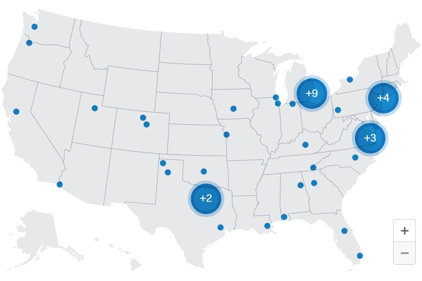 A grey map of the United States with blue dots of various sizes scattered across the country, marking the shootings.