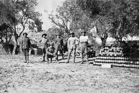 Rarotongan soldiers standing next to artillery shells