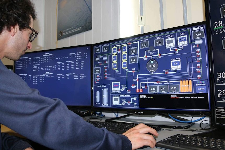 A technician monitors rocket propulsion systems