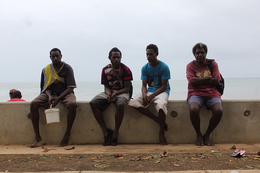Four Saibai locals sit on the new seawall on Torres Strait's largest island