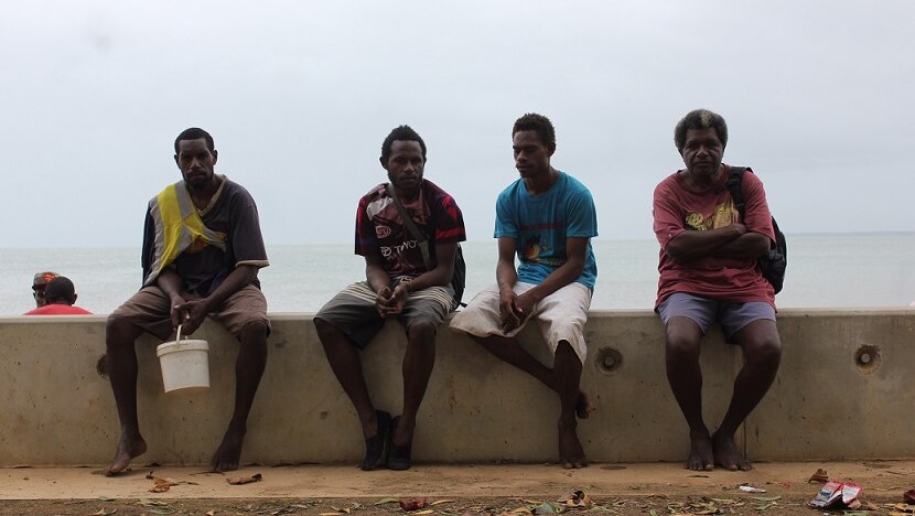 Four Saibai locals sit on the new seawall on Torres Strait's largest island